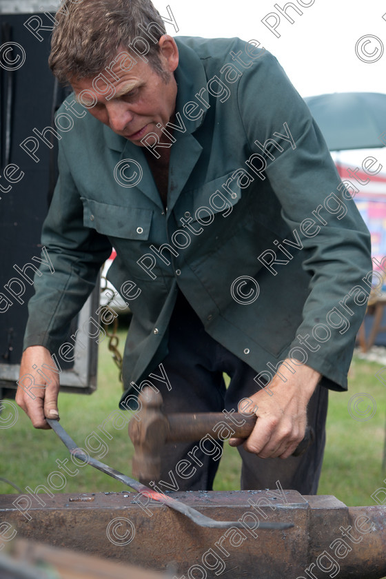 AWC 4968 
 Keywords: 2010, Ardingly, Smallholders Show, anvil, bending steel, blacksmith, happer, hitting, hot steel, july, man working